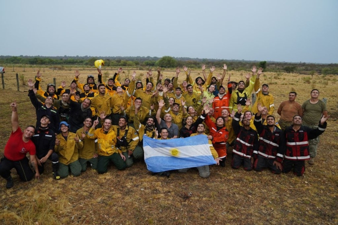 Brigadistas celebran la caída de la lluvia que ayuda a apagar focos de incendio en Corrientes. Foto: Clarín