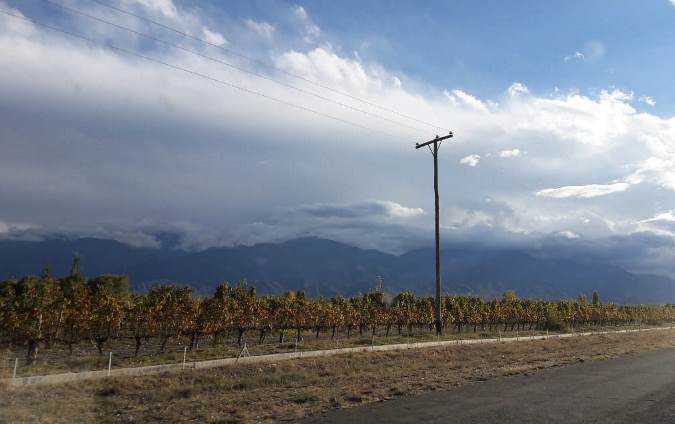 Camino al manzano con cielo ago nublado, montña y viñedos - foto abi romo