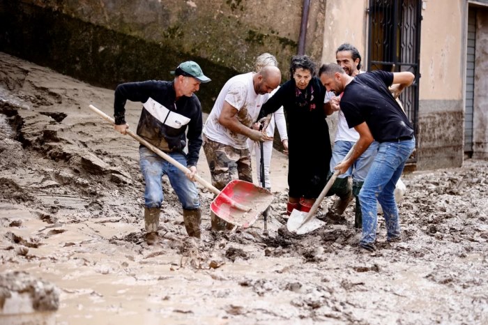 Unas personas ayudan a una señora después de que las fuertes lluvias y las mortales inundaciones afectaran a la región central italiana de Las Marcas, en Cantiano, Italia, el 16 de septiembre. REUTERS/Yara Nardi