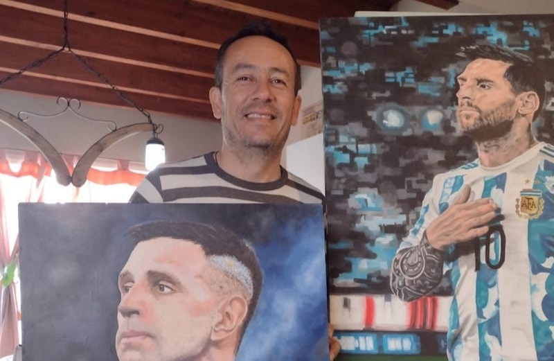 Aarón en su taller junto a dos obras icónicas: Messi y el Dibu.