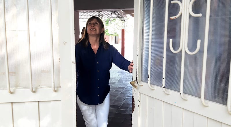 Momento exacto en que la vicedirectora de la escuela Adolfo Tula cierras las puertas de la escuela.